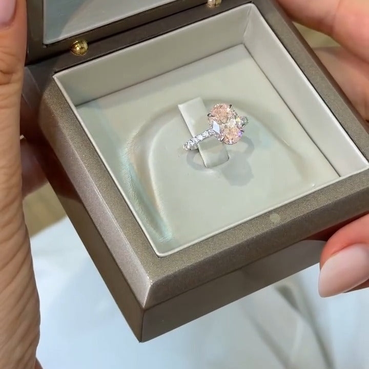 Custom pink oval engagement ring with pavé band in a BYORO ring box